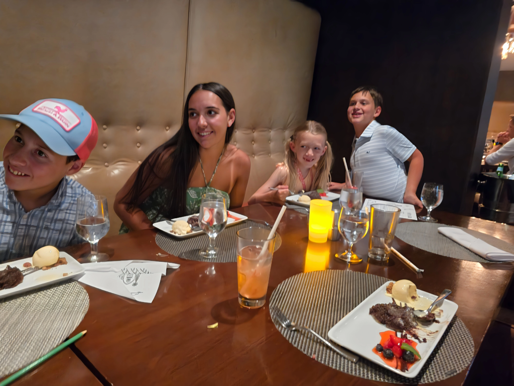 Kids at the table during a group dinner at Chops Grille on Odyssey of the Seas