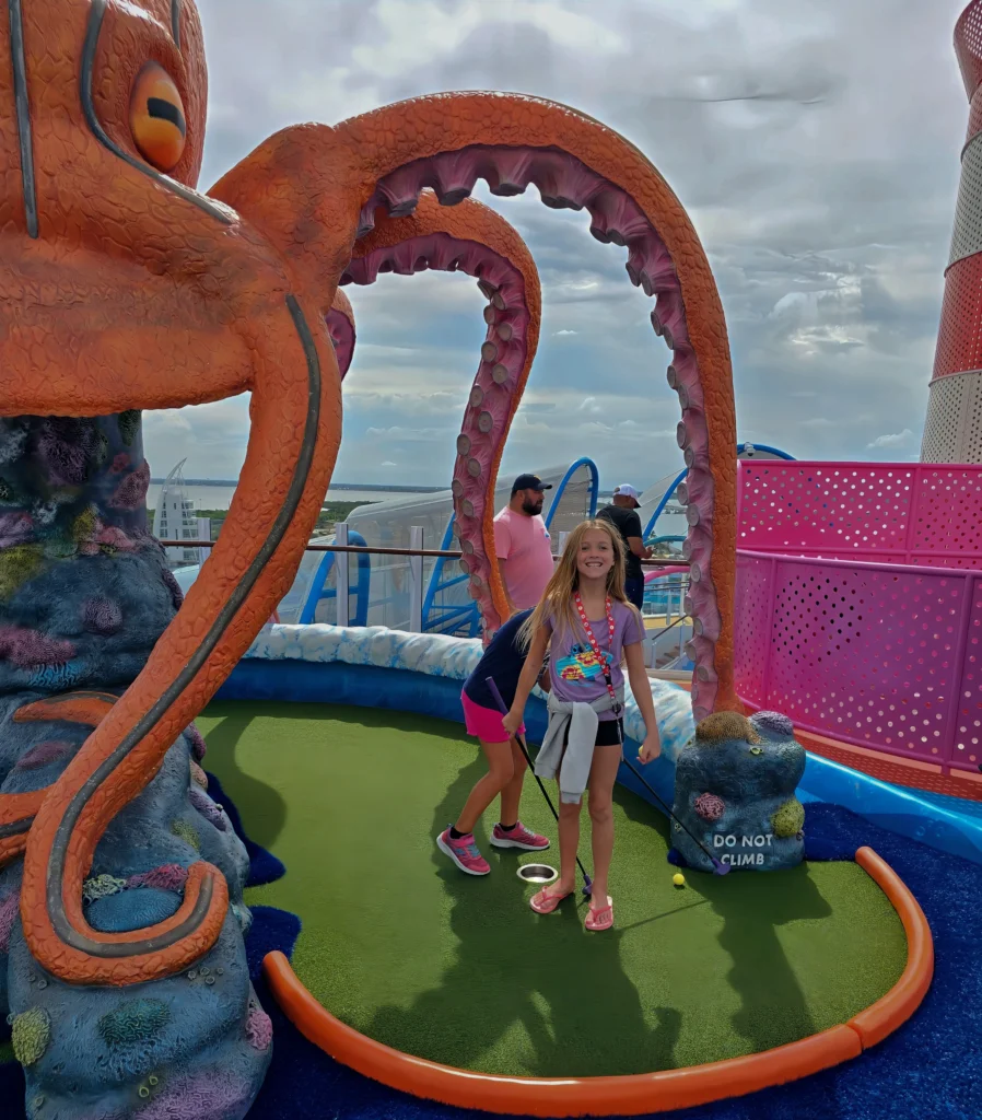 My daughter playing mini golf at Aqua Dunes on Utopia of the Seas
